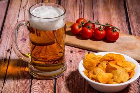 Beer on the table with chips and tomatoes Stock Photos
