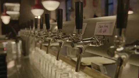 Beer Taps Lined Up in Beijing Bar Interior with Glasses and Warm Lighting Stock Footage 345761241
