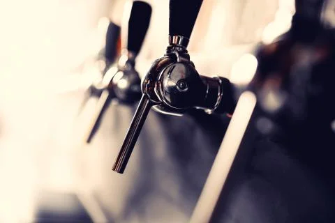 Beer taps raw in pub. Selective focus, dark background Stock Photos