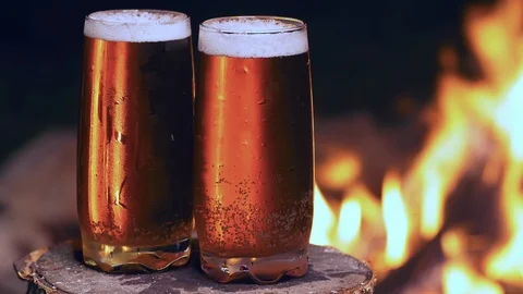 Beer time by the campfire in UHD Stock Footage 114857161