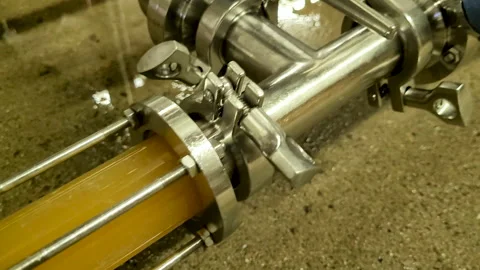 Beer transfer through a sight glass in slow motion Stock Footage 260699317