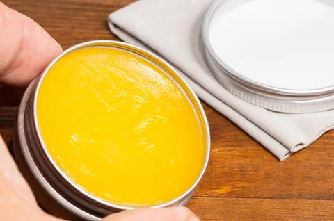 Beeswax for coating a wooden surface, held in a hand. Foto stock