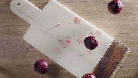 Beet falls in slow motion to the rock board on the table Stock Footage 143589783