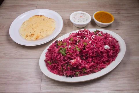 Beet risotto prepared with beet puree, roasted beet slices and parsley on top 스톡 사진