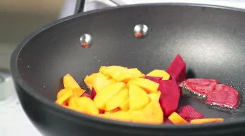 Beetroot and carrots being fried in a pan Stock Footage 24671351