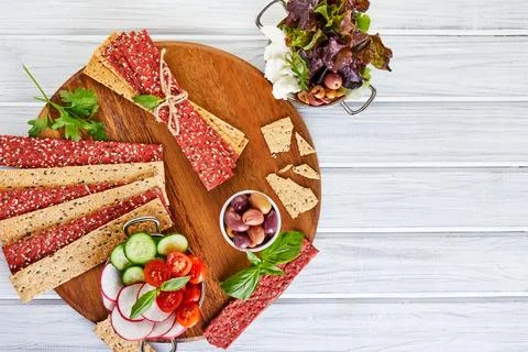 Beetroot and rye flour crackers with vegetables for making snacks on a wood.. Stock Photos