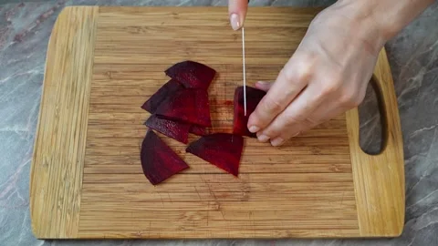 Beetroot is being cut on a wooden cutting board Stock-Footage 303482103