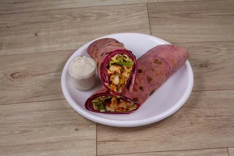 Beetroot Chicken Wrap in white plate on wooden background Stock Photos