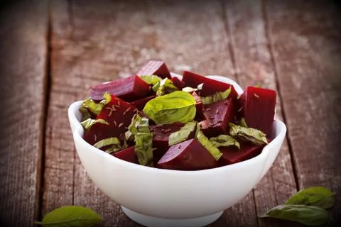 Beetroot chopped for salad with basil and dill seeds in bowl on rustic wooden Stock Photos