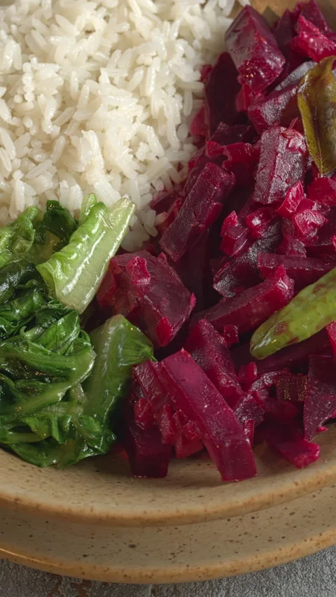 Beetroot curry with rice and stir-fried lettuce. Close-up, vertical video. Stock Footage 281832449