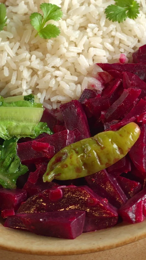 Beetroot curry with stir-fried lettuce and rice. Close-up, vertical video. Stock Footage 283728744