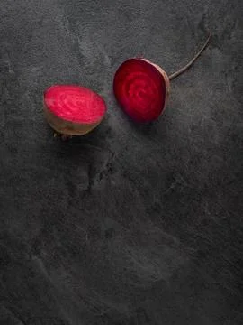 Beetroot cut in half on dark table. Overhead shot. Stock Photos