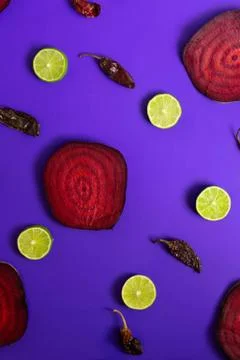Beetroot in the form of a pattern with lemon slices on a purple background Stock Photos