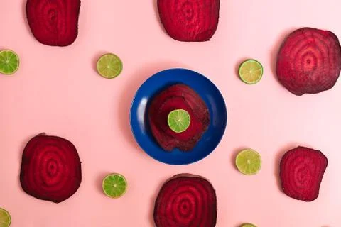 Beetroot in the form of a pattern with lemon slices on a pink background Stock Photos