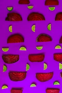 Beetroot in the form of a pattern with lemon slices on a purple background Stock Photos