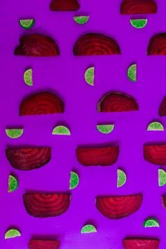 Beetroot in the form of a pattern with lemon slices on a pink background Stock Photos