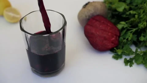 Beetroot juice garnished with mint leaves and slices pouring in a clear glass Video stock 155771579