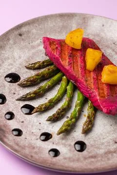 Beetroot marinated salmon with asparagus and pineapple. Stock Photos