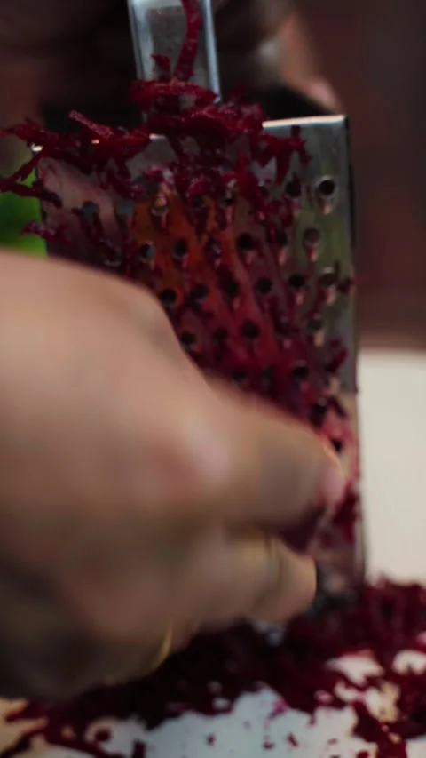 Beetroot peeling on a board. beetroot peeling through a stainless steel grater. Stock Footage 283361781