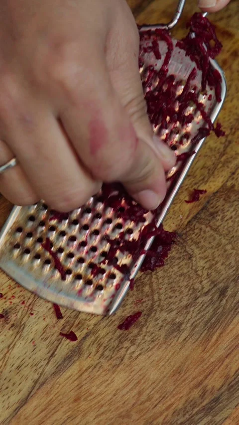 Beetroot peeling on a board. beetroot peeling through a stainless steel grater. Stock Footage 283361829