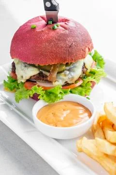 Beetroot red bun cheeseburger set with fries and chilli mayo Stock Photos