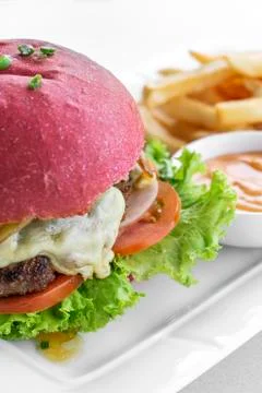 Beetroot red bun cheeseburger set with fries and chilli mayo Stock Photos
