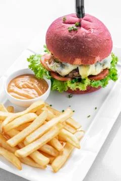 Beetroot red bun cheeseburger set with fries and chilli mayo Stock Photos