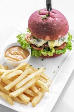 Beetroot red bun cheeseburger set with fries and chilli mayo Stock Photos