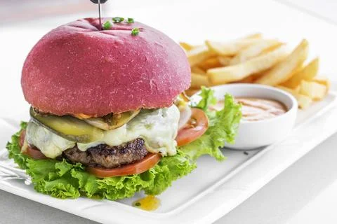 Beetroot red bun cheeseburger set with fries and chilli mayo Stock Photos