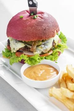 Beetroot red bun cheeseburger set with fries and chilli mayo Stock Photos