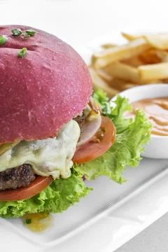 Beetroot red bun cheeseburger set with fries and chilli mayo Stock Photos