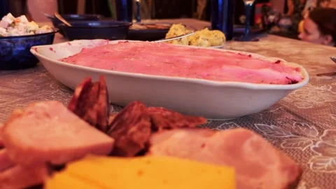 Beetroot salad with mayonnaise herring under a fur coat on the home table, close Stock Footage 307199956