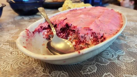 Beetroot salad with mayonnaise herring under a fur coat on the home table, close Stock Footage 308005359
