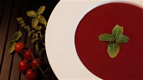 Beetroot soup on black background, with cherry tomato enhances wholesome Foto stock