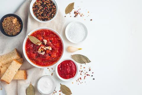 Beetroot soup with garlic, bread and spices on a white background. Stock Photos