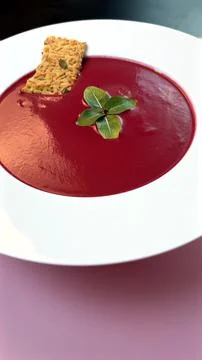 Beetroot soup served in pristine white plate contrasts strikingly with pink Stock Photos