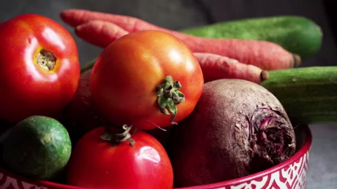 Beetroot, tomato, and cucumber in a bowl against a grey backdrop	 Stock Footage 310790300