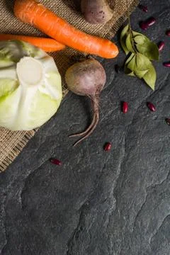 Beets, carrots and cabbage during cooking. Composition on a dark background. Stock Photos