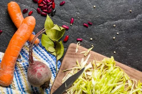Beets, carrots and cabbage during cooking. Composition on a dark background Stock Photos