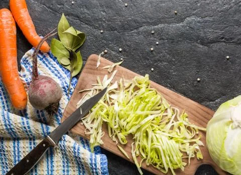 Beets, carrots and cabbage during cooking. Composition on a dark background Stock Photos