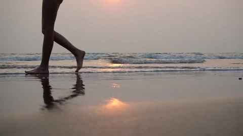 Beger of the sea at sunset. the rolling waves. A man walks barefoot in the sand. Stock Footage 149396094