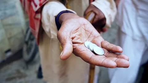 Beggar asking alms in the form of coins stretching a dirty old hand with a Stock Footage 74304906