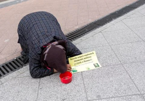 Beggar lying on the ground Stock Photos