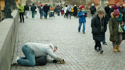 Beggar pitiful man homeless poor kneeling begging counts money people tourist Stock Footage 331722185