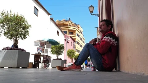 Beggar sits on the street and eats 動画素材 123144842