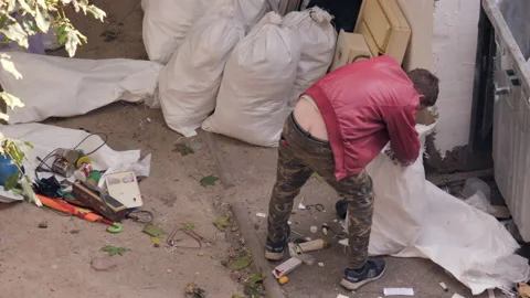 Beggar Sorting Things Out Of A Garbage Bag Stock Footage 163638289