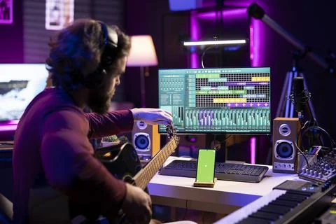 Beginner artist learning strings accords to play guitar by watching tutorials Stock Photos