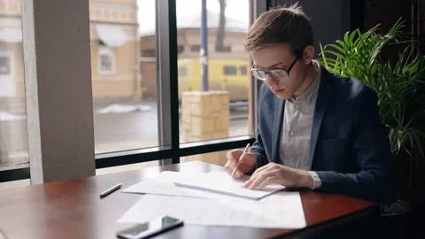 Beginner businessman is working on startup project sitting at table in cafe. Stock Footage 92237567