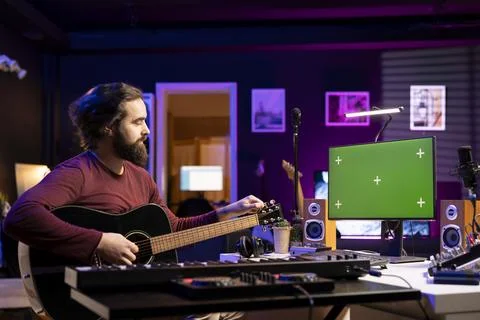 Beginner composer trying to tune his guitar strings for a new song Foto stock