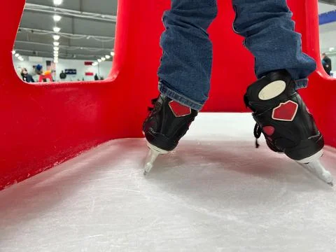 Beginner ice skater using a plastic walker for assistance. Stock Photos